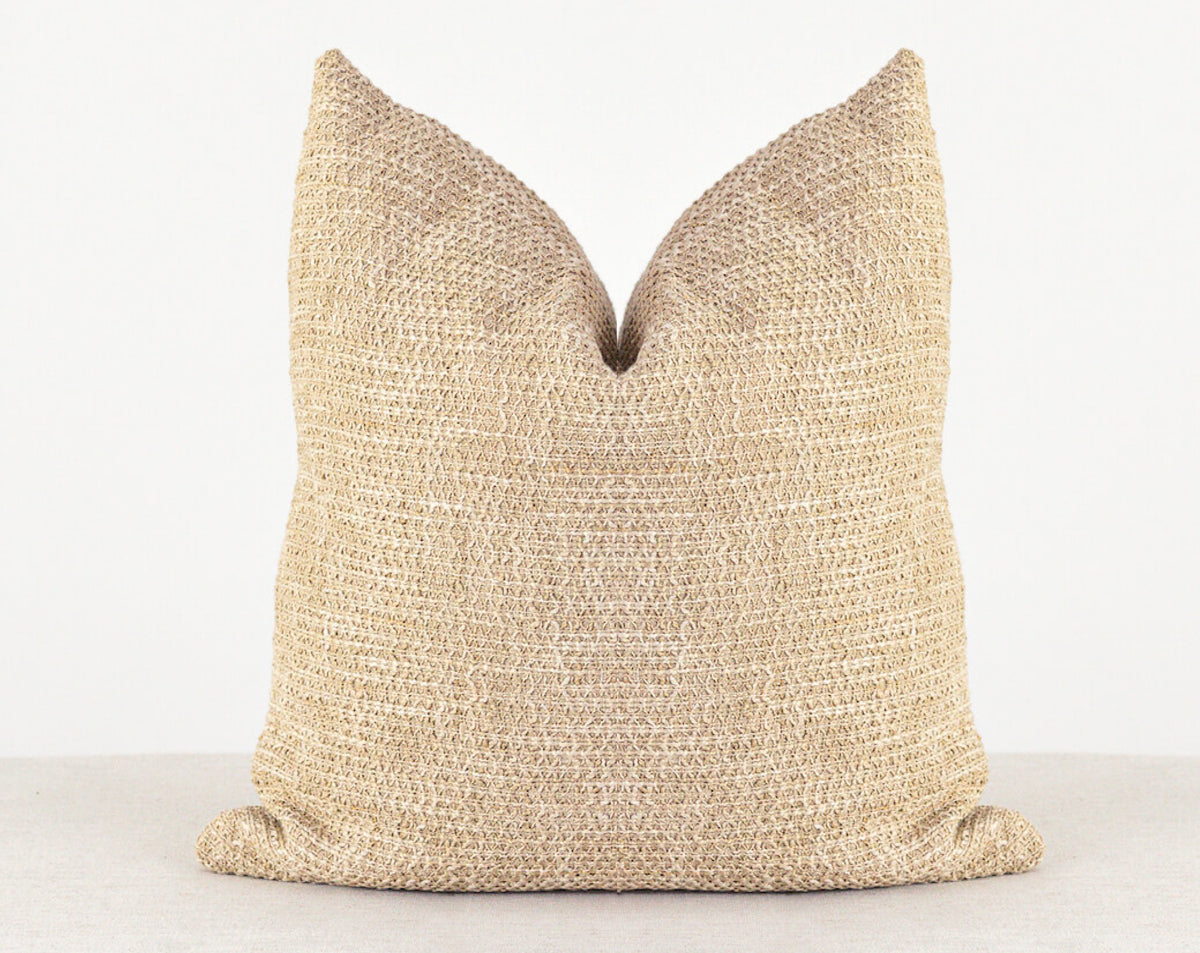 features a bright tan chunky woven pillow cover.